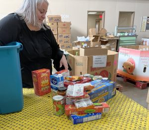 The Director of Operations at the Food Bank of Central New York sorting nonperishable food items for distribution.