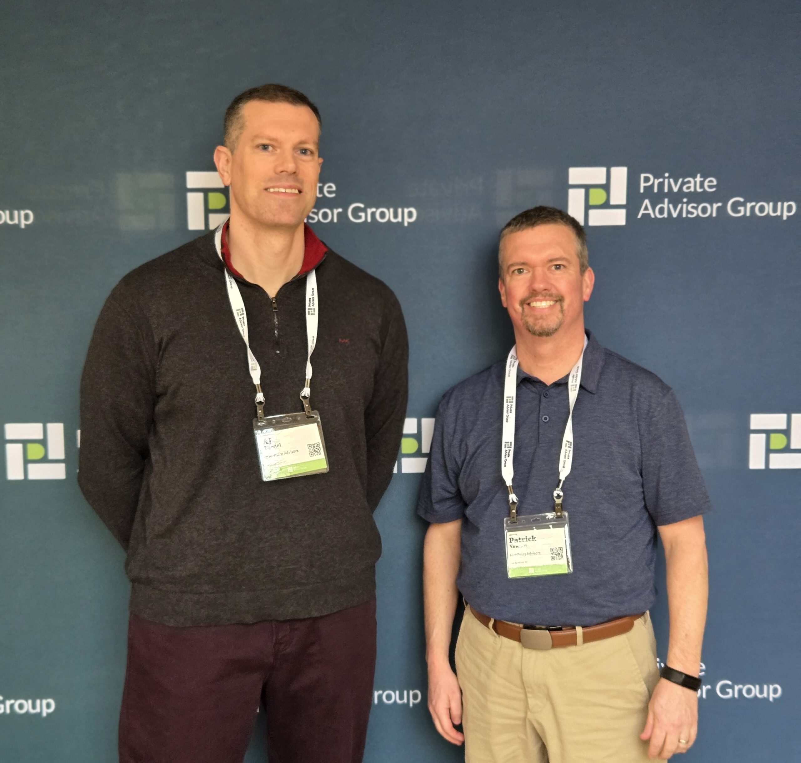 AJ and Pat of HighPoint Advisors, LLC in Syracuse, NY, pose in front of the Private Advisor Group sign at their conference in Philadelphia.