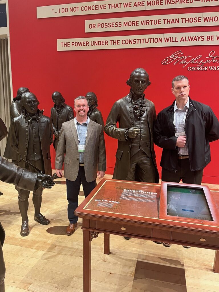 AJ of HighPoint Advisors, LLC in Syracuse, NY, pose with statues of some of the Founding Fathers in Philadelphia during the Private Advisor Group conference.