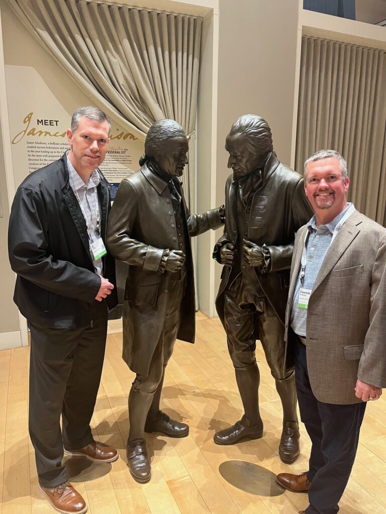 AJ of HighPoint Advisors, LLC in Syracuse, NY, pose with statues of some of the Founding Fathers in Philadelphia during the Private Advisor Group conference.