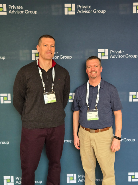 AJ and Pat of HighPoint Advisors, LLC in Syracuse, NY, pose in front of the Private Advisor Group sign at their conference in Philadelphia.
